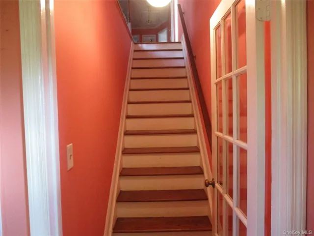 a view of staircase with wooden floor and white walls