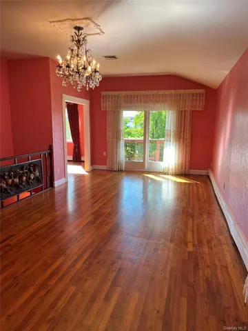 a view of a room with wooden floor staircase and a kitchen