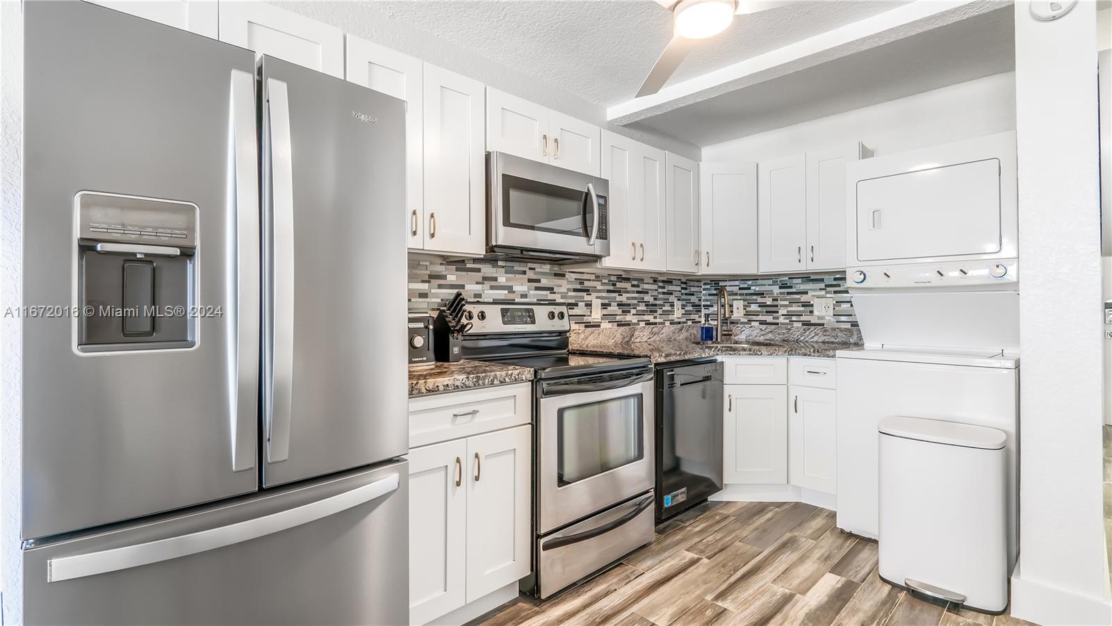 201 Van Buren Street, Unit 103 Hollywood, FL 33019 - Photo 11 of 25 a kitchen with stainless steel appliances a stove microwave and refrigerator