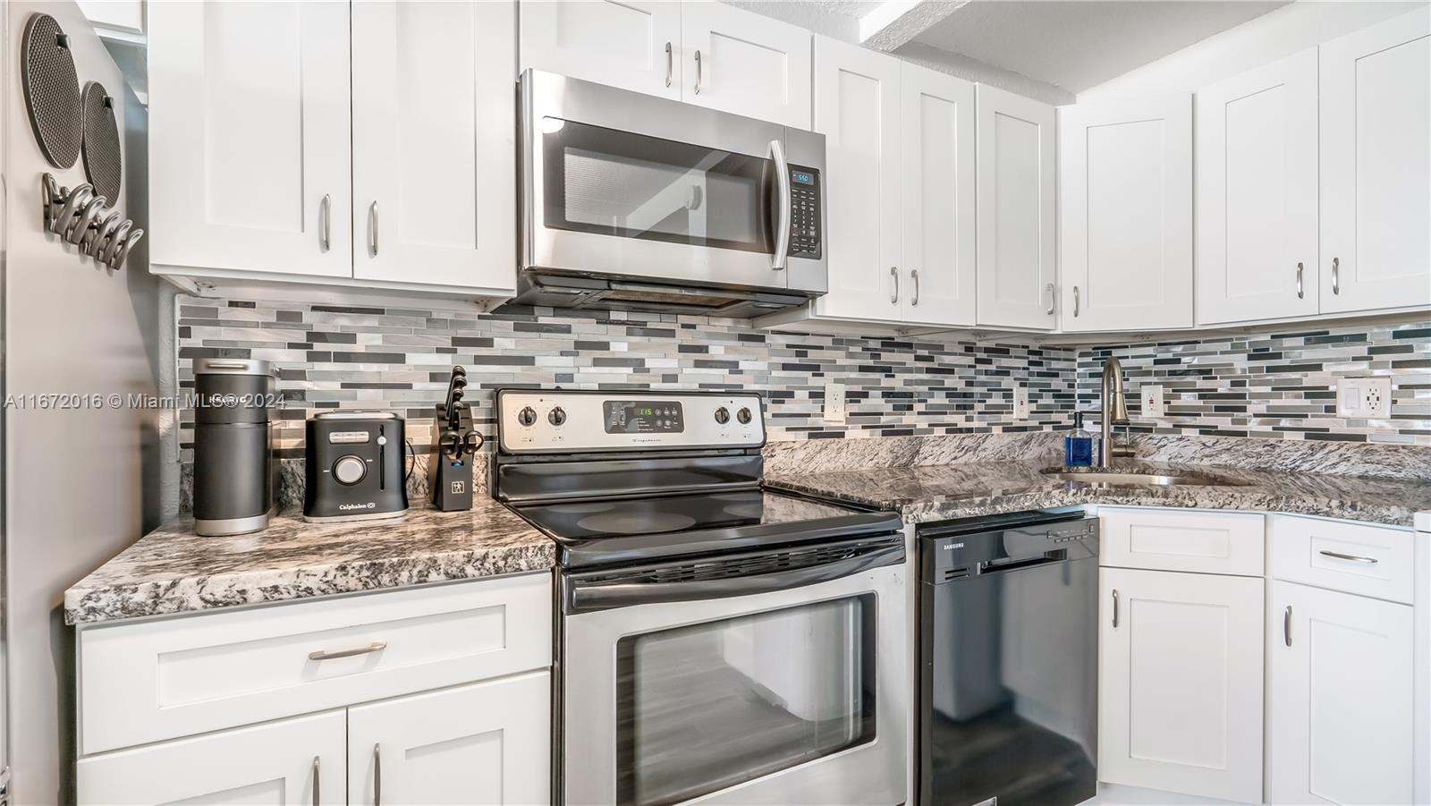 201 Van Buren Street, Unit 103 Hollywood, FL 33019 - Photo 12 of 25 a stove top oven sitting inside of a kitchen