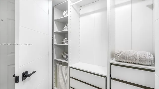 a hallway with white cabinets and wooden floor