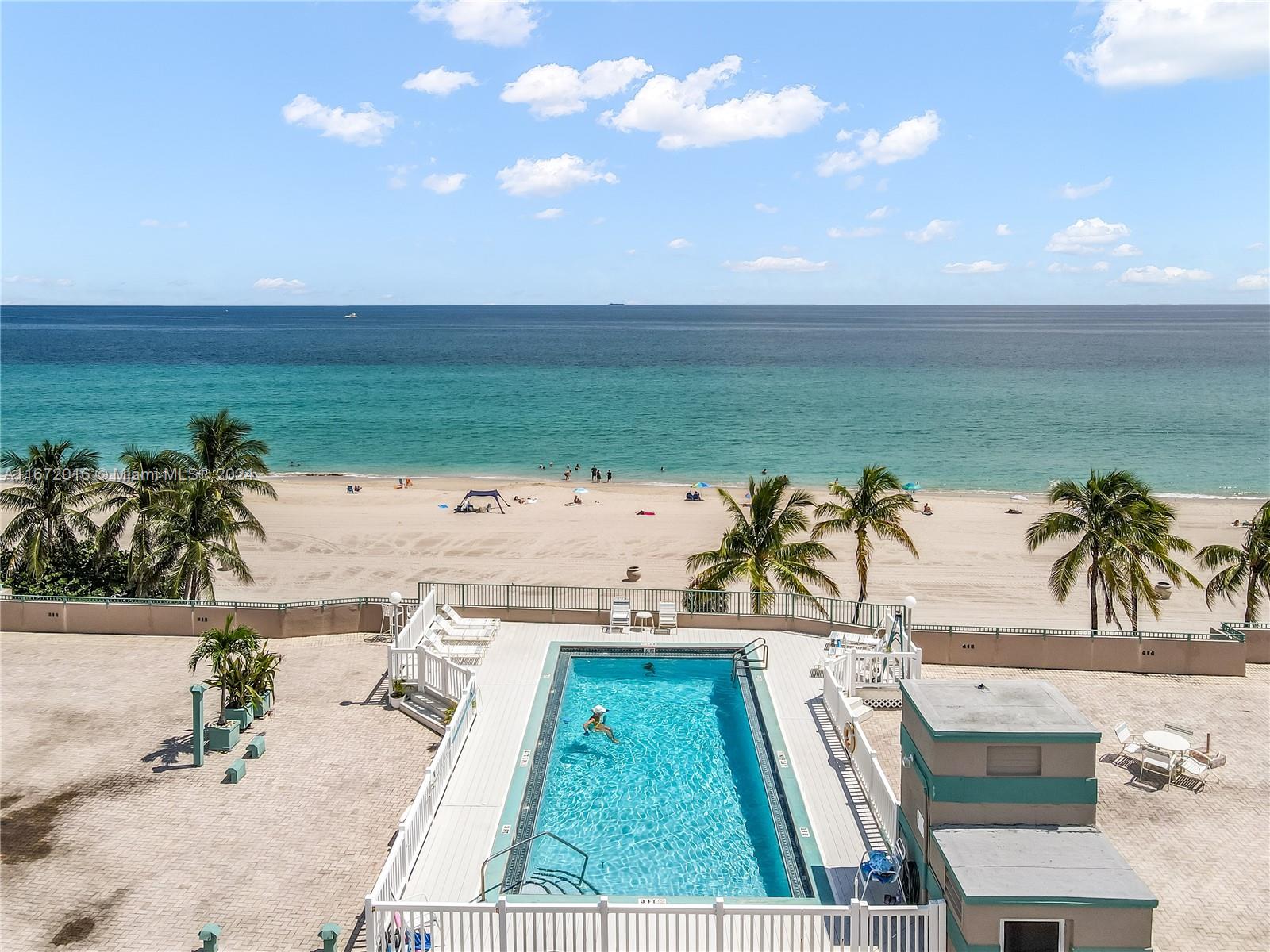 201 Van Buren Street, Unit 103 Hollywood, FL 33019 - Photo 21 of 25 a view of a swimming pool with a lawn chairs