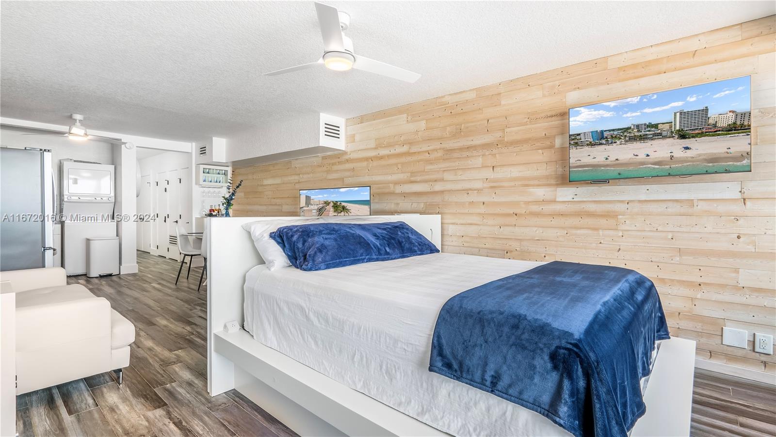 201 Van Buren Street, Unit 103 Hollywood, FL 33019 - Photo 6 of 25 a bedroom with a bed and a wall painting