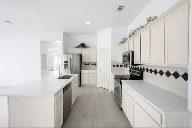 a large kitchen with a large window and stainless steel appliances