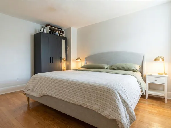 a bedroom with a bed and a wooden floor