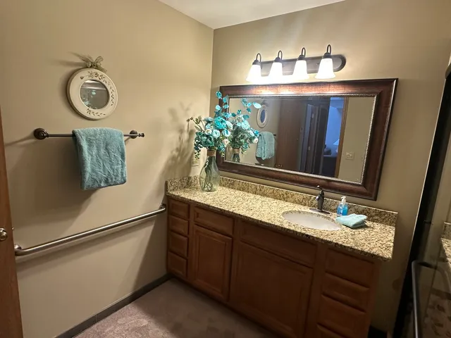 a bathroom with a granite countertop toilet and a shower