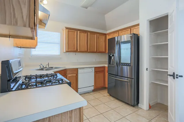 a kitchen with stainless steel appliances granite countertop a refrigerator and a stove