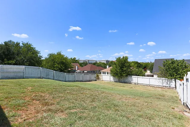 a view of a yard with a house in the background