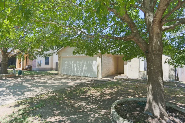 a view of a house with a tree in front of it