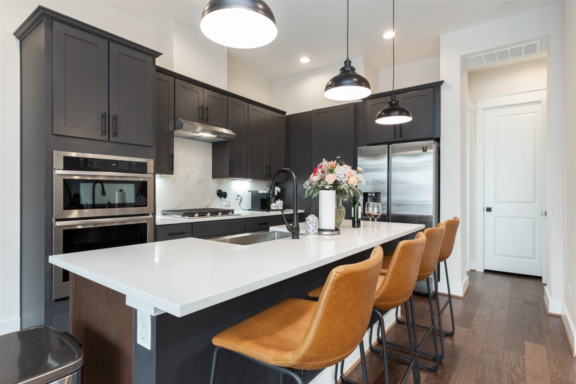 605 Middle Street Houston, TX 77003 - Photo 5 of 33 a kitchen with a dining table chairs stainless steel appliances and cabinets