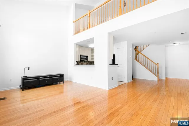 a view of a livingroom with wooden floor and stairs