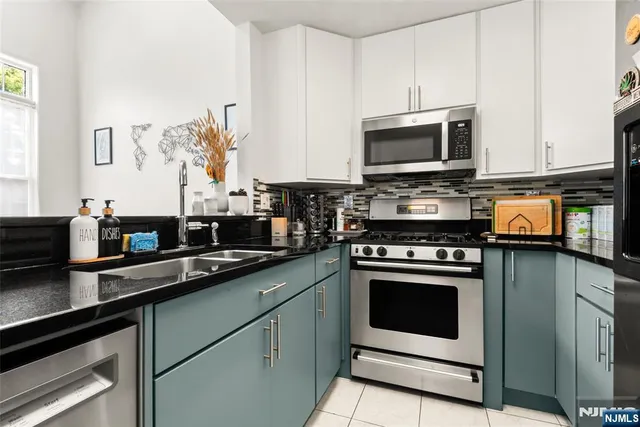 a kitchen with stainless steel appliances granite countertop a stove microwave and sink