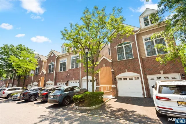 a front view of a building with cars parked