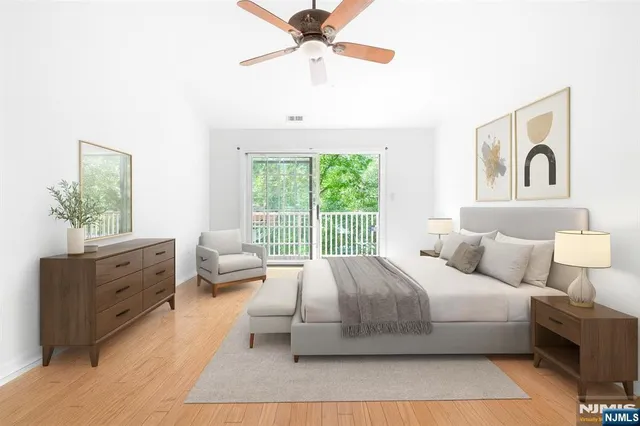 a bedroom with a large bed and a chandelier fan
