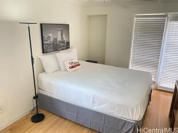 a bedroom with a bed and wooden floor