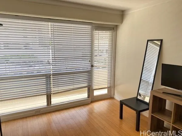a view of a room with a window and wooden floor