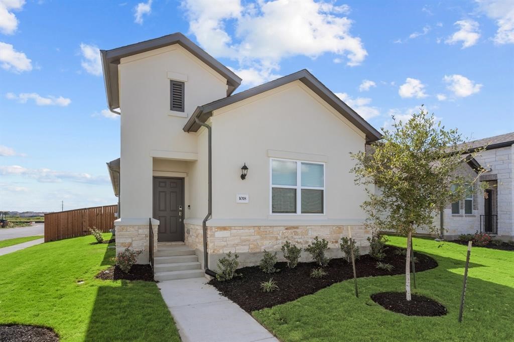 View of front of property featuring stone siding and stucco siding