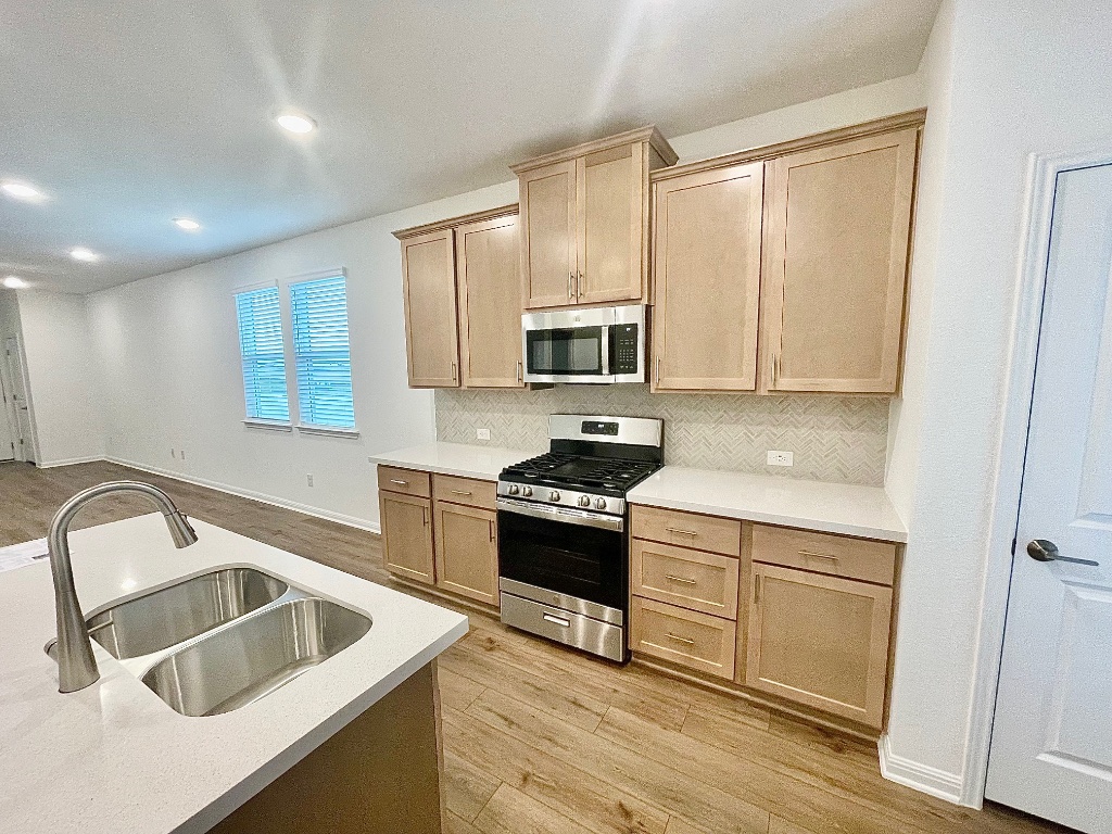 1018 Vanderscile Road Hutto, TX 78634 - Photo 3 of 27 a kitchen that has a sink and a stove top oven