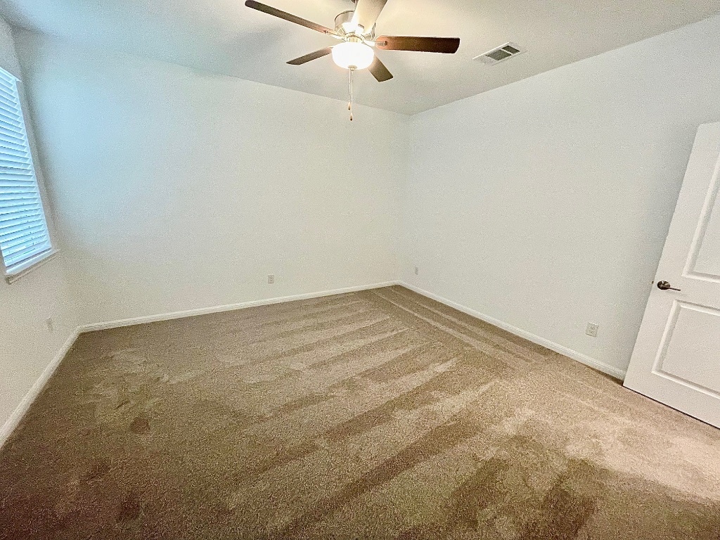 1018 Vanderscile Road Hutto, TX 78634 - Photo 7 of 27 an empty room with a window and a fan