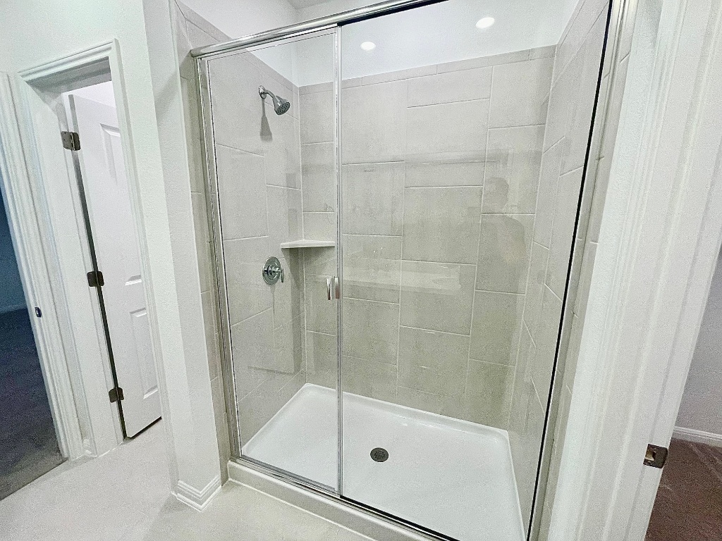 1018 Vanderscile Road Hutto, TX 78634 - Photo 9 of 27 a bathroom with a glass door shower