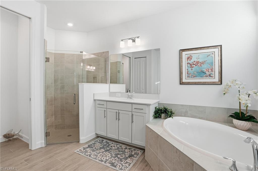 44481 Mesquite Lane Babcock Ranch, FL 33982 - Photo 23 of 34 a spacious bathroom with a double vanity sink a large mirror a shower and a bathtub