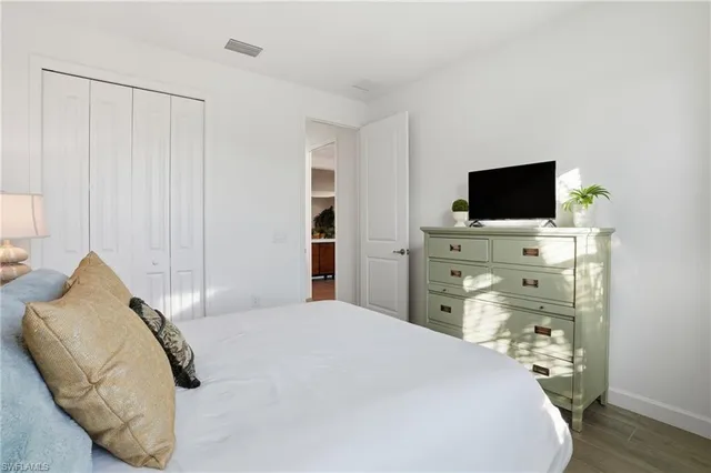 a bedroom with a bed and a flat screen tv