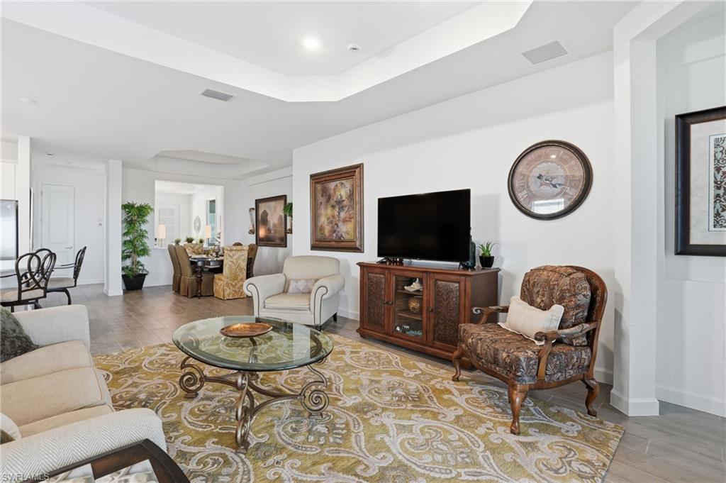 44481 Mesquite Lane Babcock Ranch, FL 33982 - Photo 8 of 34 a living room with furniture a flat screen tv and a wall clock