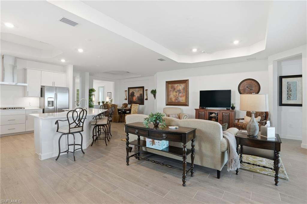 44481 Mesquite Lane Babcock Ranch, FL 33982 - Photo 9 of 34 a living room with furniture a flat screen tv and a table