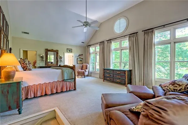 a bed sitting in a spacious bedroom next to a window