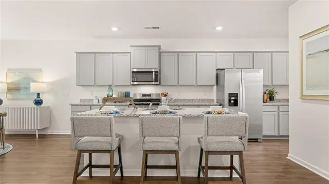 a kitchen with a dining table chairs and refrigerator