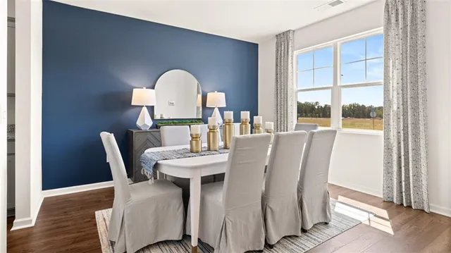 a kitchen with stainless steel appliances a stove a sink a refrigerator white cabinets and wooden floor