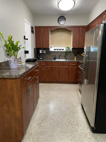 a kitchen with stainless steel appliances granite countertop a refrigerator a stove and a refrigerator