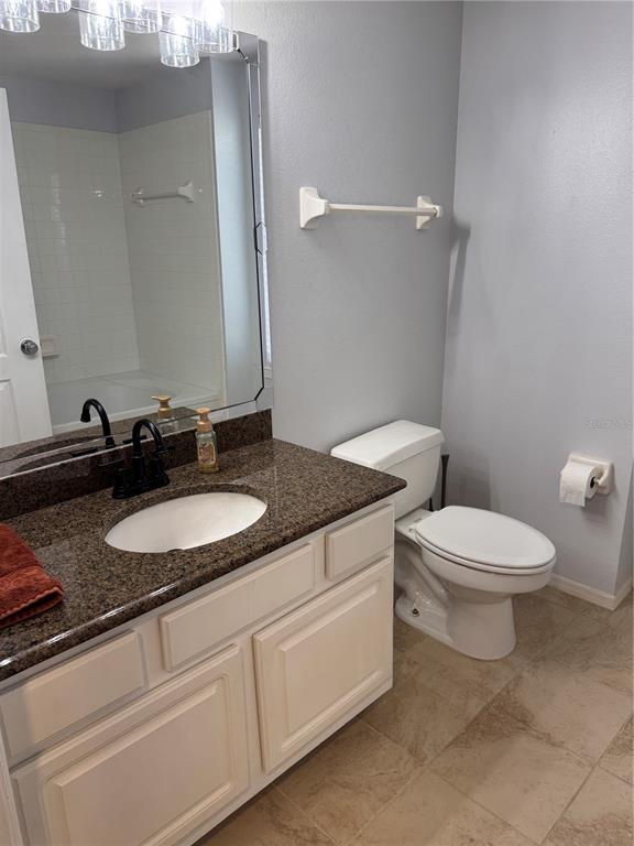 416 Summit Ridge Place, Unit 316 Longwood, FL 32779 - Photo 13 of 24 a bathroom with a granite countertop toilet sink and mirror