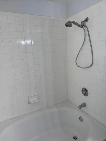 a bathroom with a bath tub with a shower