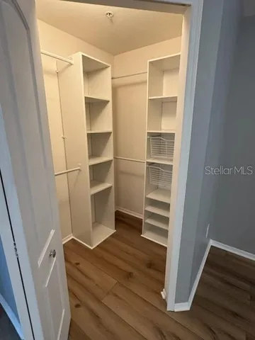 a view of walk in closet with empty racks