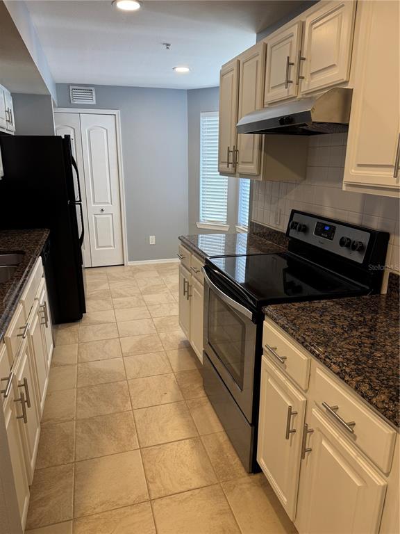 416 Summit Ridge Place, Unit 316 Longwood, FL 32779 - Photo 6 of 24 a kitchen with granite countertop a stove and a refrigerator