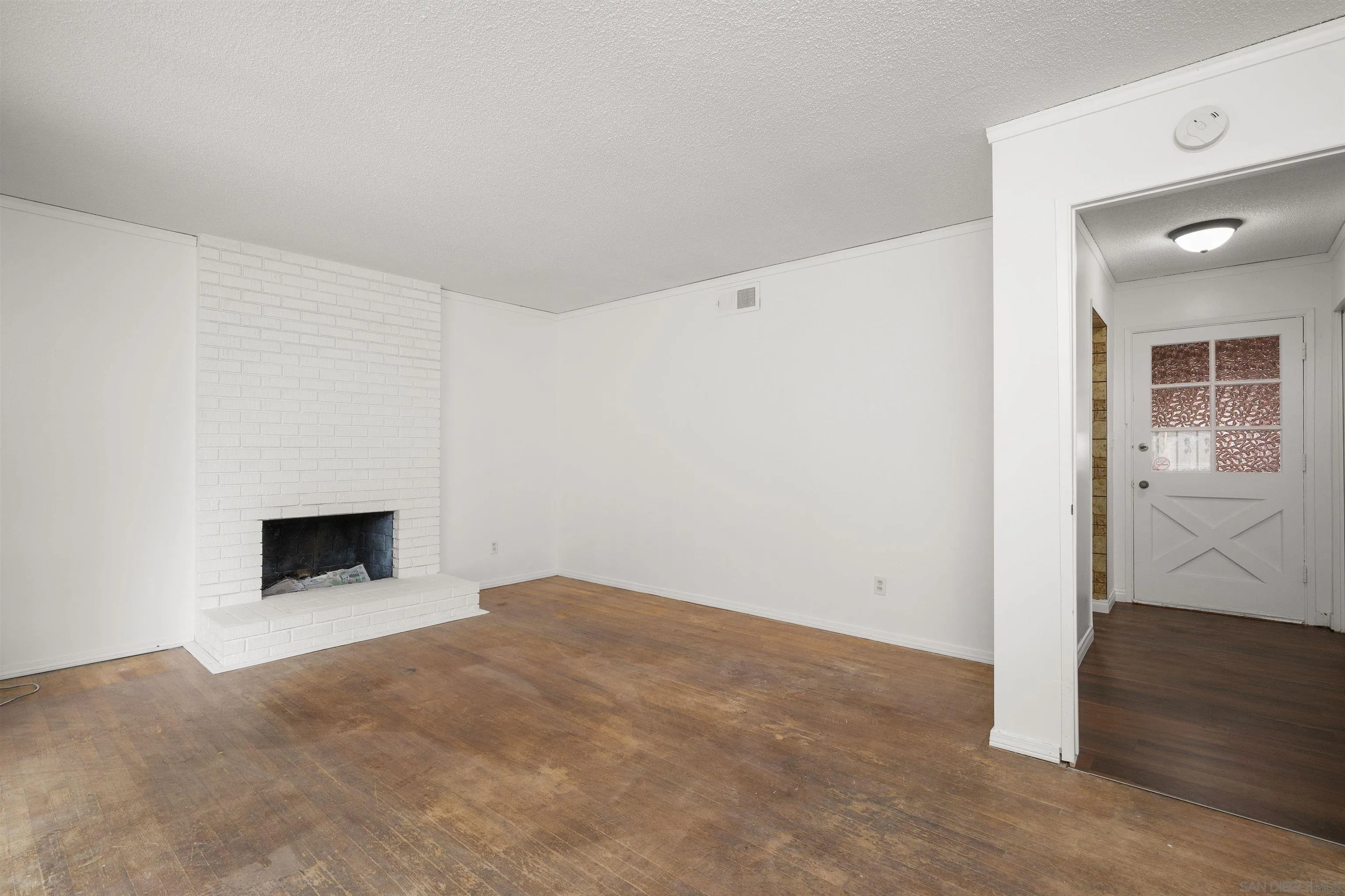2854 Rhoades Road San Diego, CA 92139 - Photo 3 of 10 a view of empty room with wooden floor and fireplace