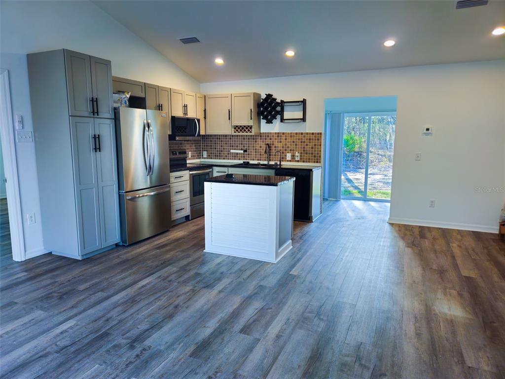 12293 Southwest 89th Street Dunnellon, FL 34432 - Photo 11 of 21 a kitchen with wooden floors stainless steel appliances and window