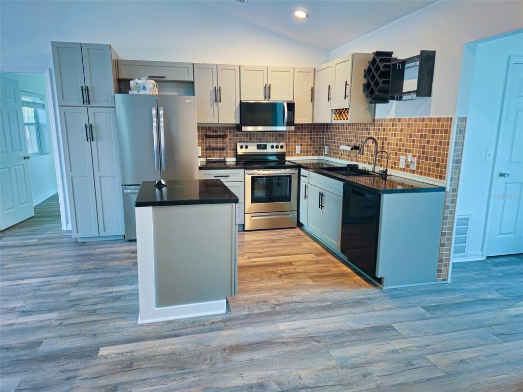 12293 Southwest 89th Street Dunnellon, FL 34432 - Photo 10 of 21 a kitchen with stainless steel appliances a refrigerator and a stove top oven