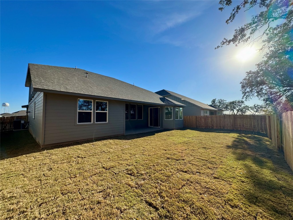 1788 South Main Street Kyle, TX 78640 - Photo 5 of 7 Rear view of property featuring a patio, a fenced backyard, and roof with shingles