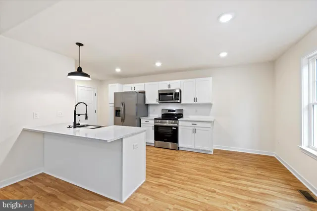 a kitchen with a sink stainless steel appliances and cabinets