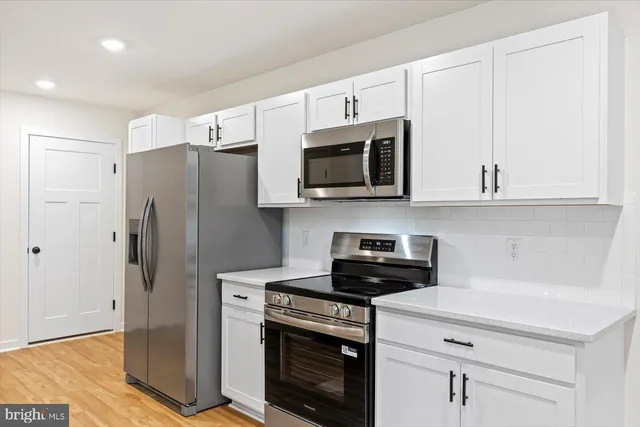 a kitchen with stainless steel appliances a stove microwave and refrigerator