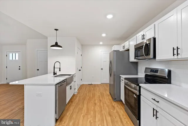 a kitchen with stainless steel appliances granite countertop a sink stove and microwave