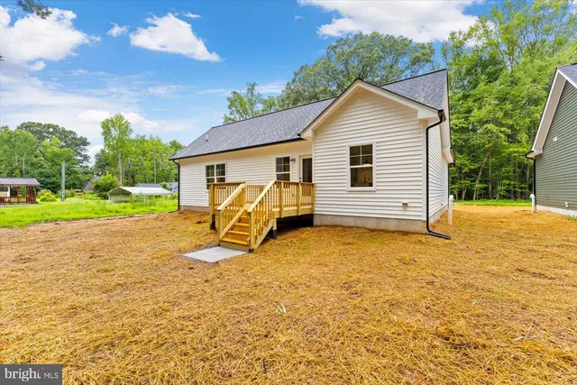 a view of a house with backyard and trees