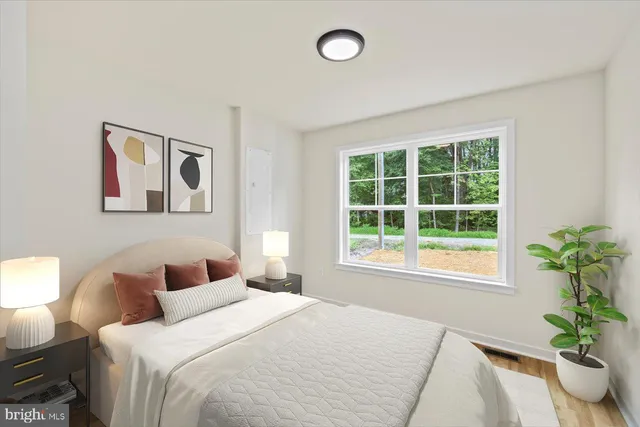 a bedroom with a large bed and a potted plant