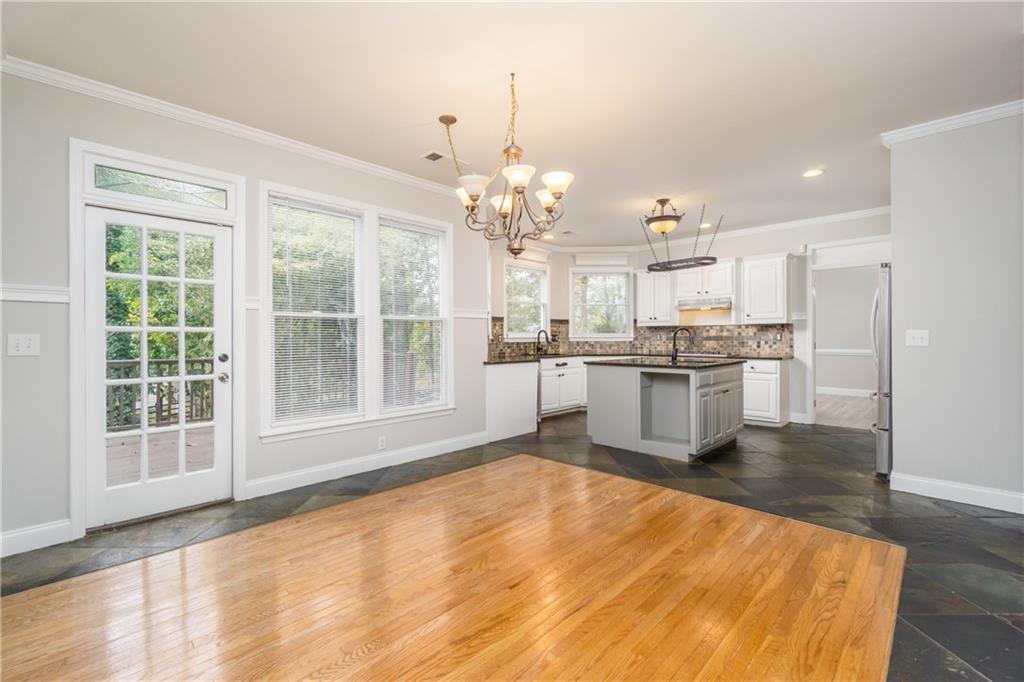 6710 Timber Cove Cumming, GA 30041 - Photo 23 of 42 a kitchen with kitchen island a stove a refrigerator a sink dishwasher with a dining table and chairs