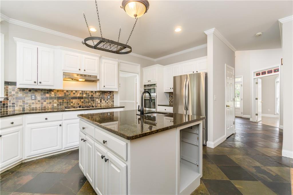 6710 Timber Cove Cumming, GA 30041 - Photo 7 of 42 a kitchen with stainless steel appliances granite countertop a sink a stove a refrigerator and island with wooden floor