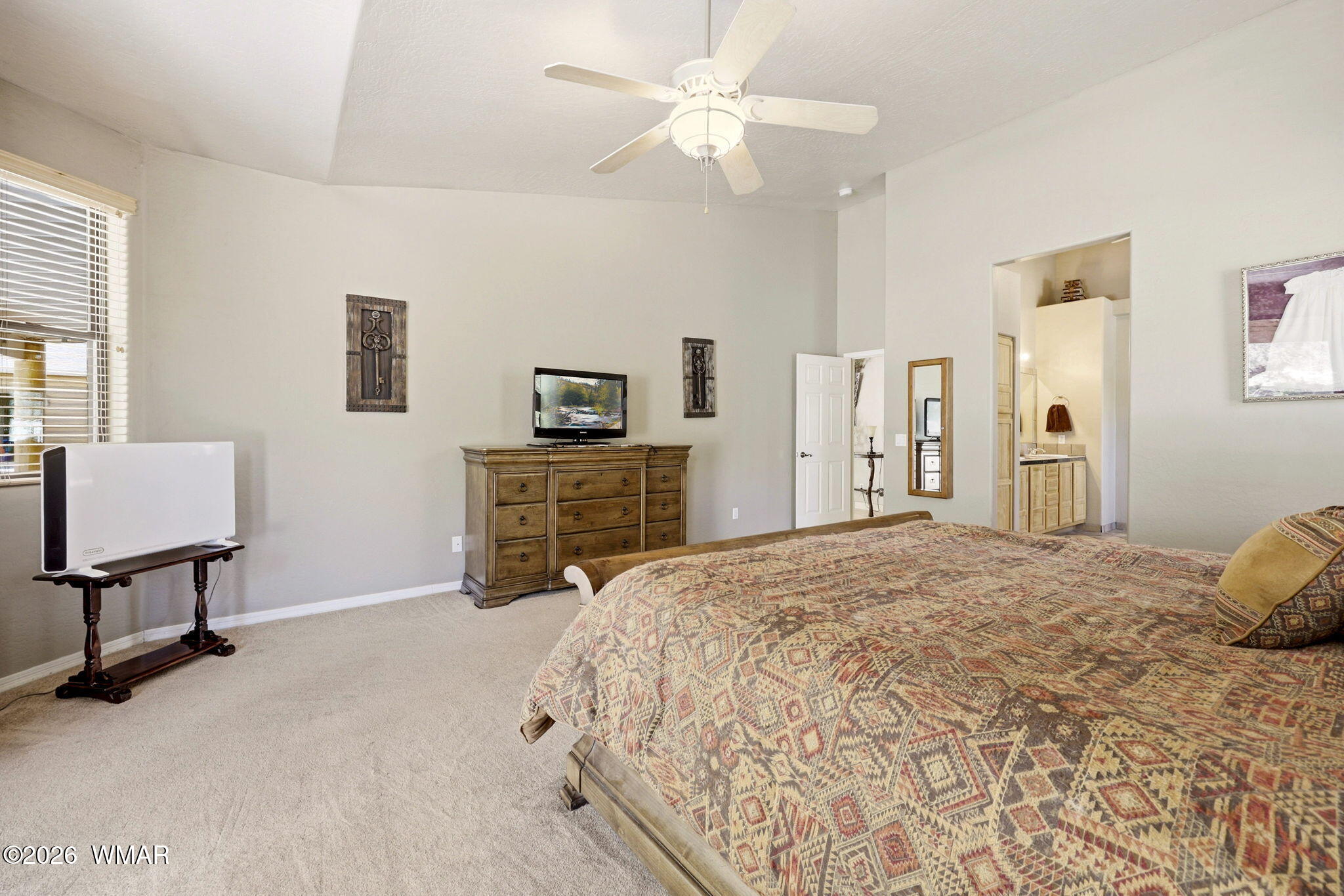 2236 Roundabout Way Overgaard, AZ 85933 - Photo 15 of 45 a spacious bedroom with a bed a dresser and a chandelier