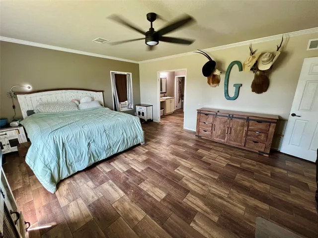 a bedroom with a large bed and a ceiling fan