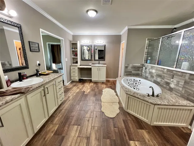 a spacious bathroom with a granite countertop sink mirror vanity and bathtub